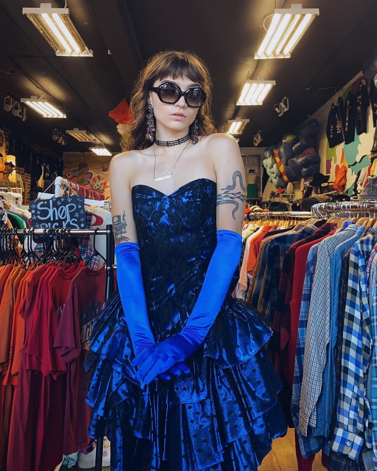 Woman in a blue velvet strapless dress and long gloves in a vintage shop
