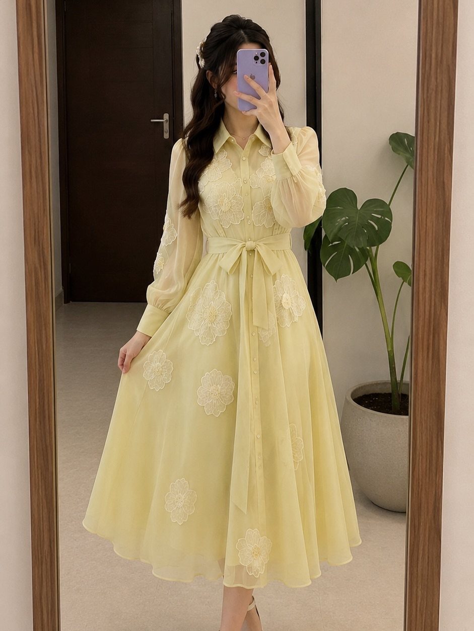 Woman in a pale yellow embroidered maxi dress posing for a mirror selfie.