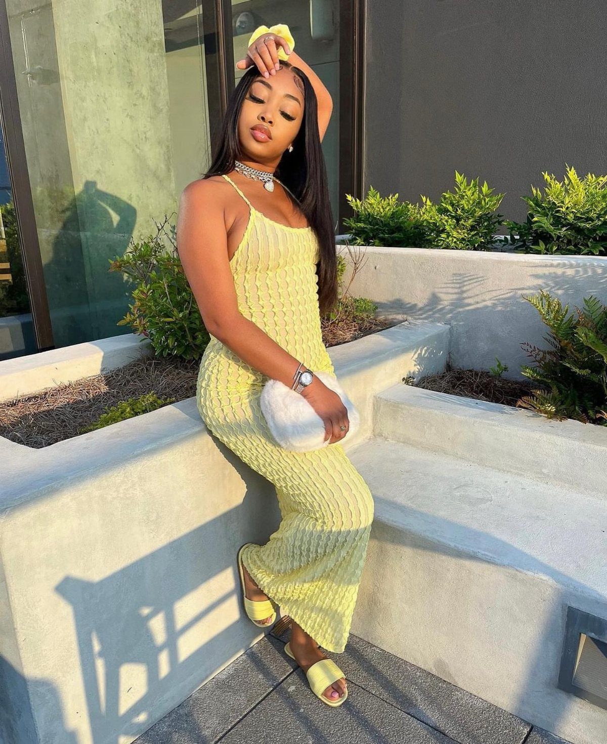 Woman in a yellow ribbed maxi dress and matching sandals posing outdoors.